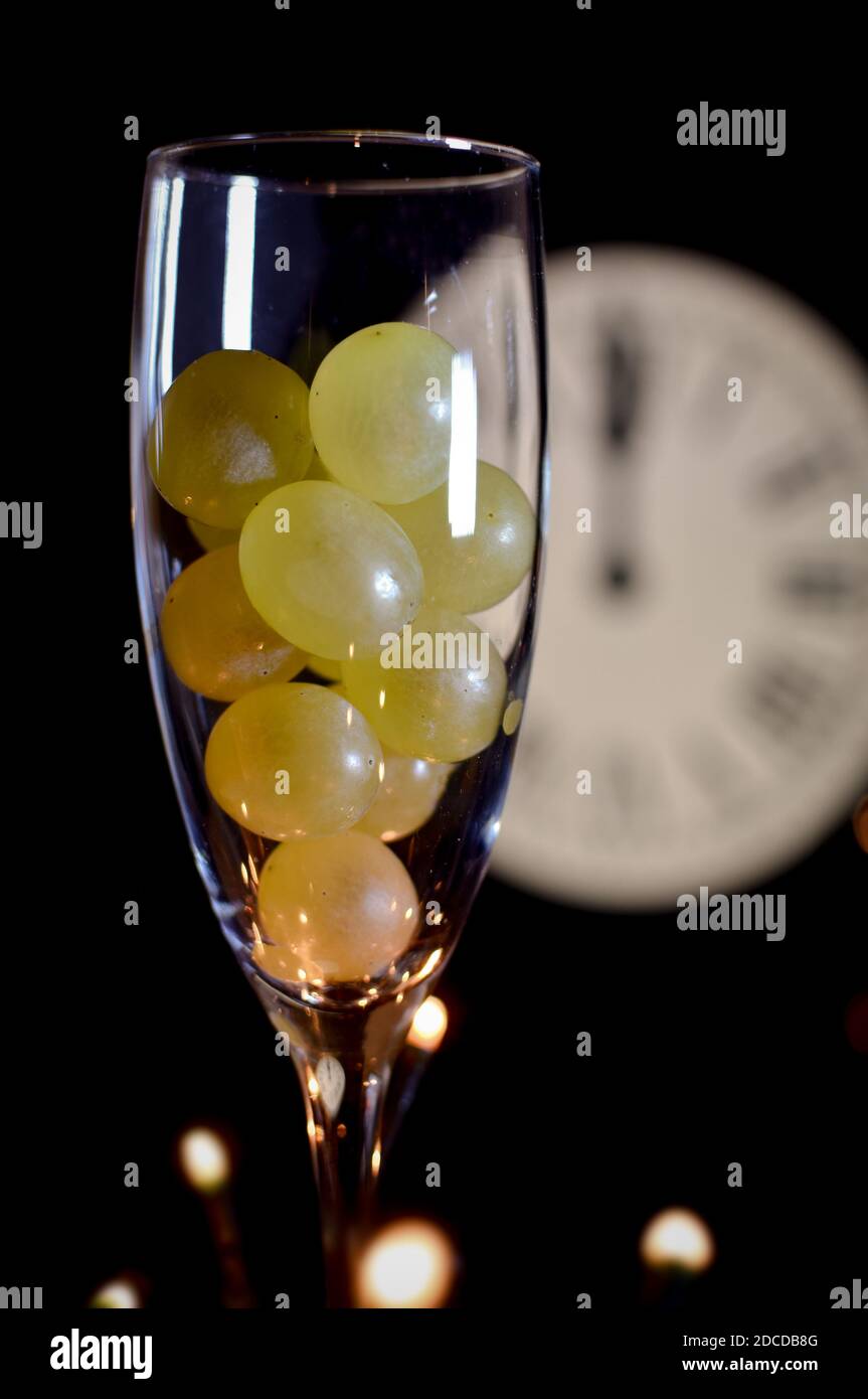 CELEBRATION OF THE NEW YEAR, TRADITION OF TWELVE GRAPES OF LUCK WITH THE CLOCK WITH TWELVE BELLS Stock Photo