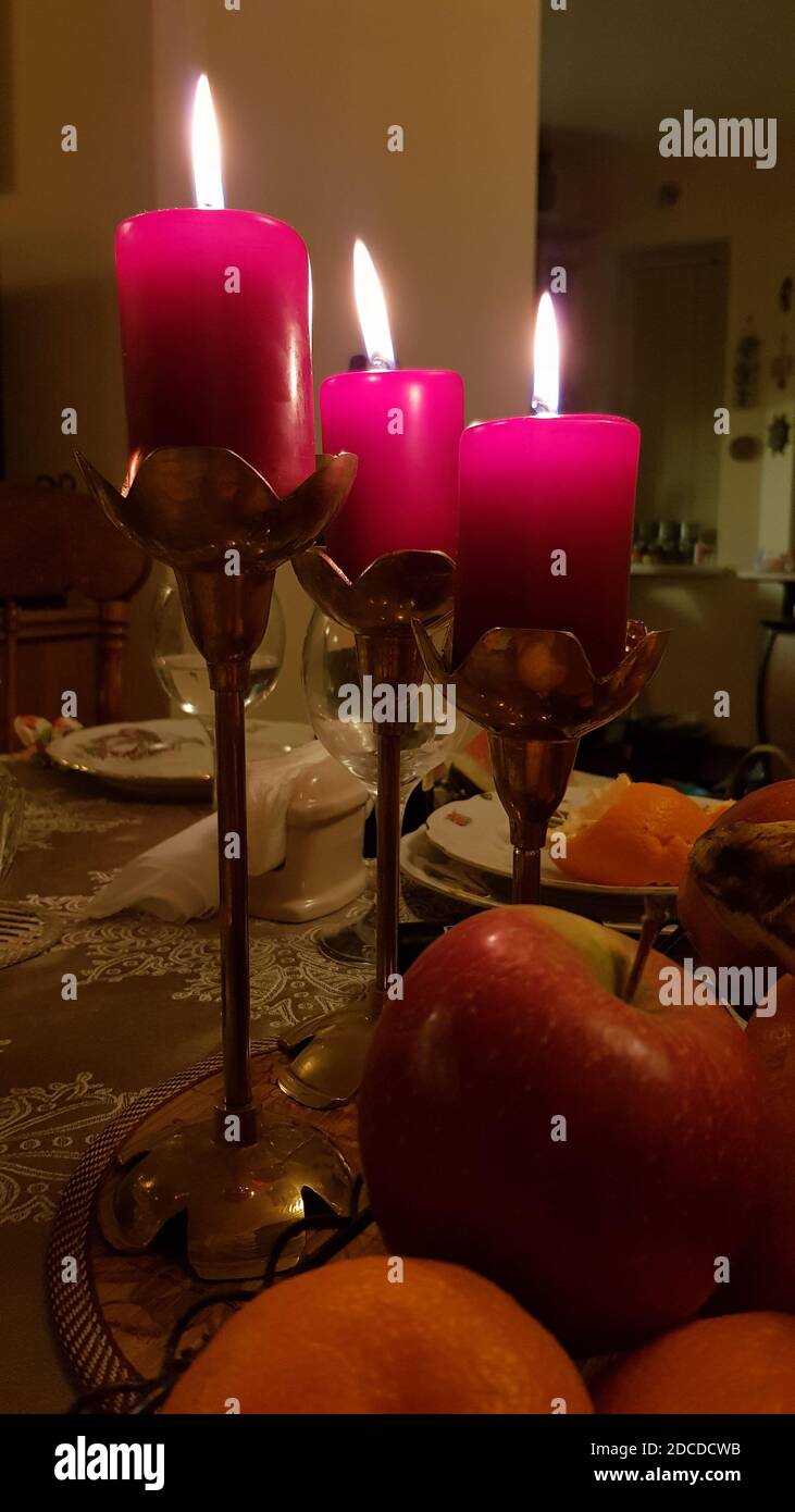 Holiday table with three red candles in vintage brass candelabras