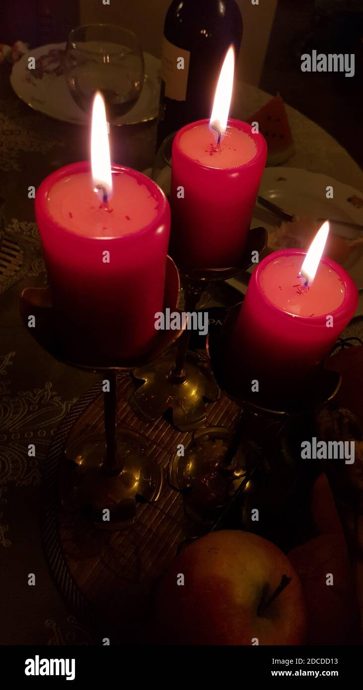 Holiday table with three red candles in vintage copper candelabras