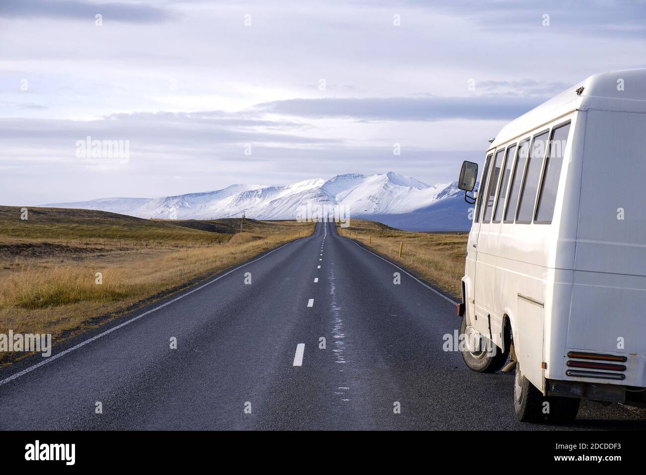White bus on the side of a desert mountain road in Iceland Stock Photo