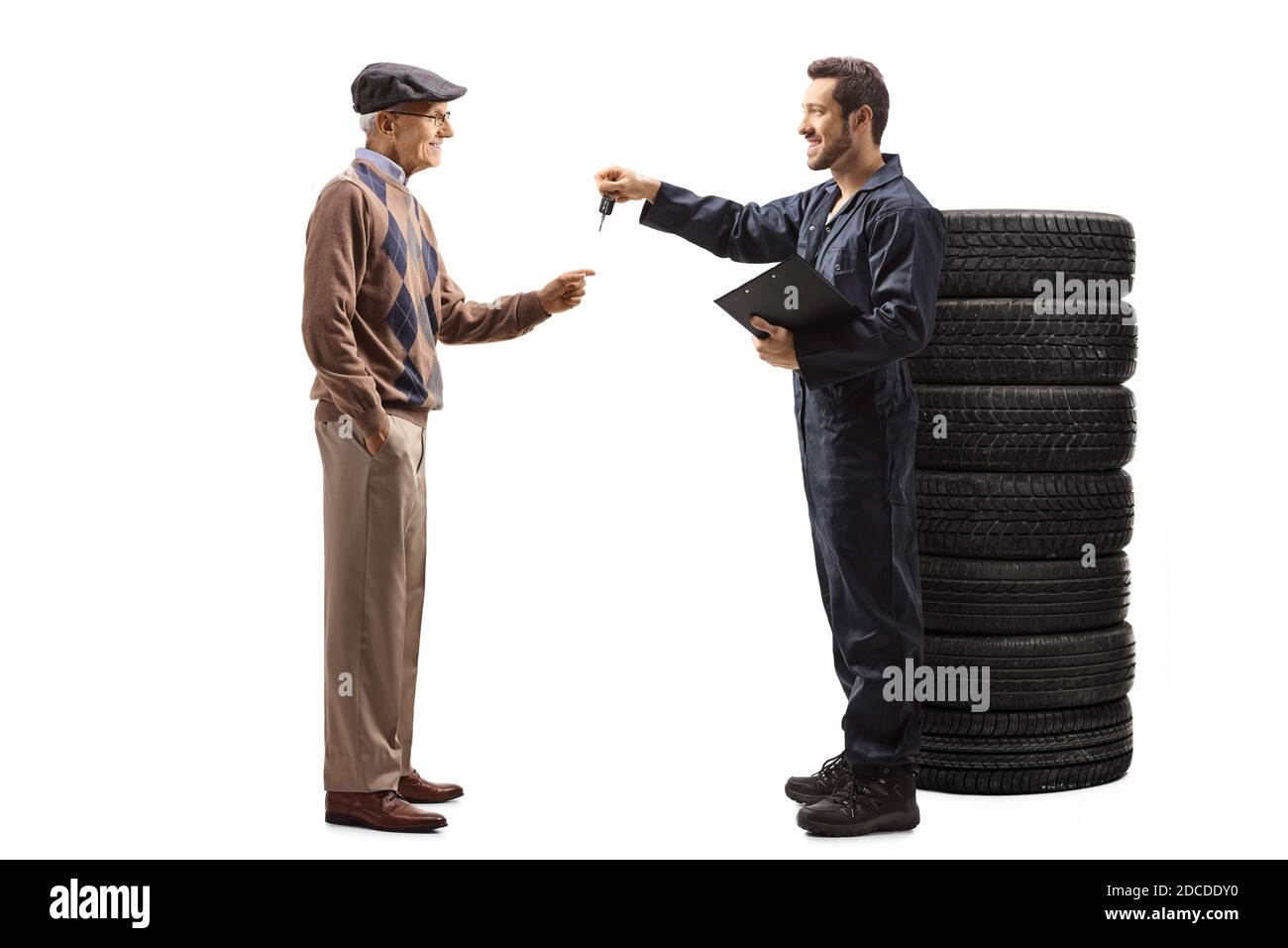 Full length profile shot of an autot mechanic worker returning car keys to an elderly man isolated on white background Stock Photo