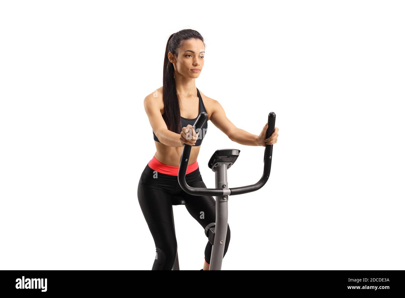 Young woman in sportswear exercising on a stationary bike isolated on white background Stock Photo