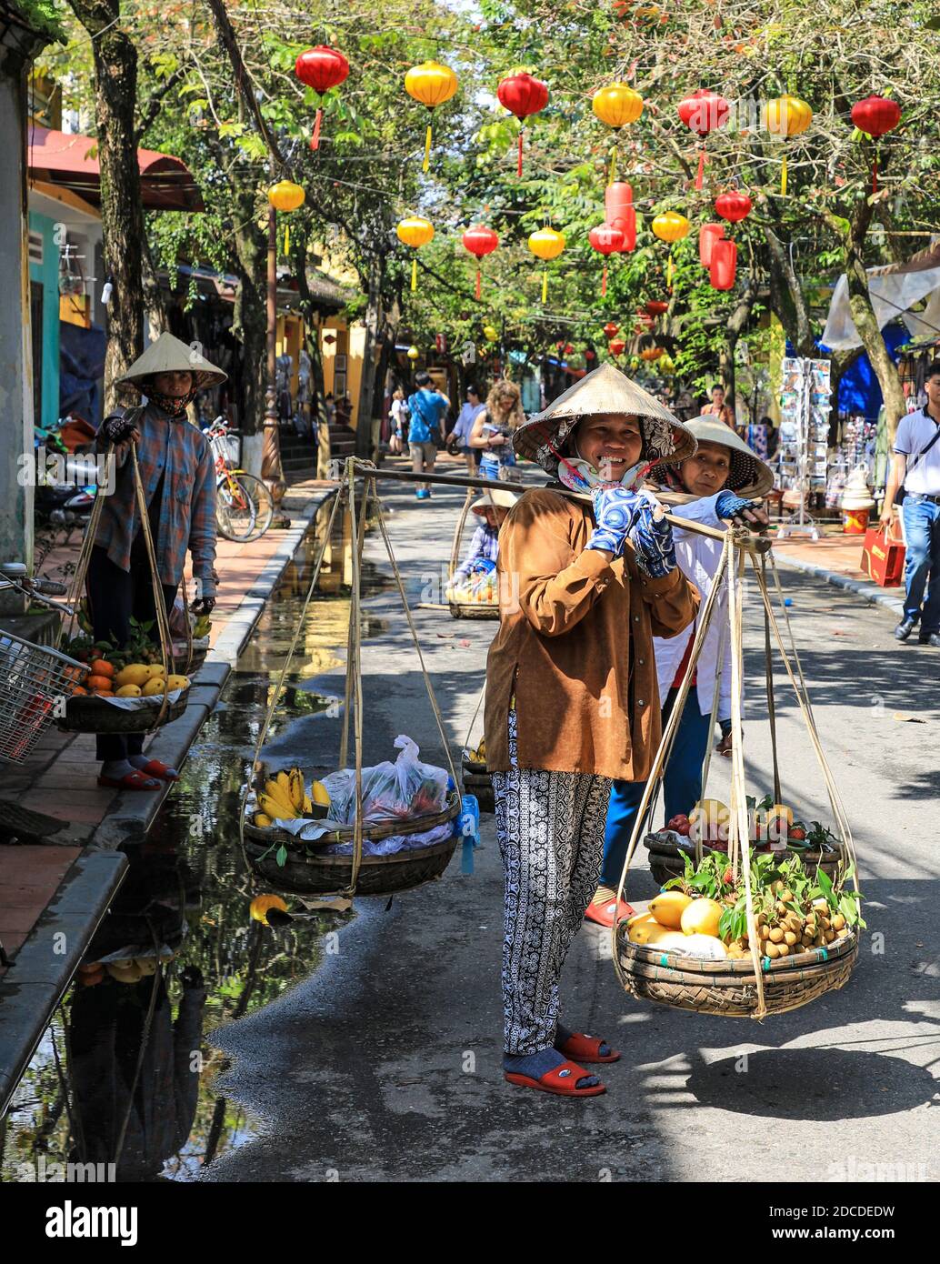 Women fruit sellers wearing Vietnamese traditional conical hats, on the street at Hoi An
