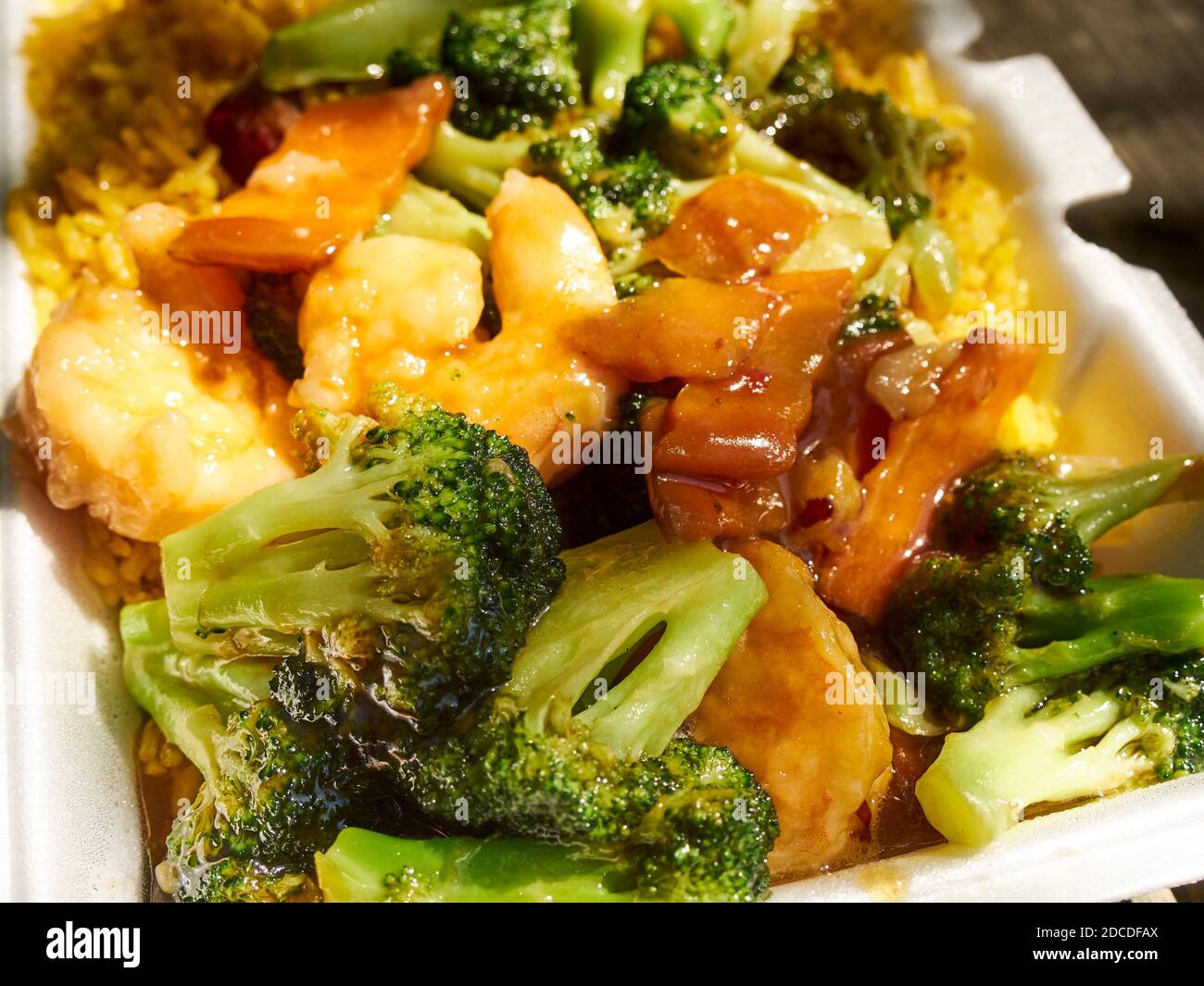 Shrimp with broccoli over fried rice - an iconic Chinese/American takeout dish in a plastic foam container Stock Photo