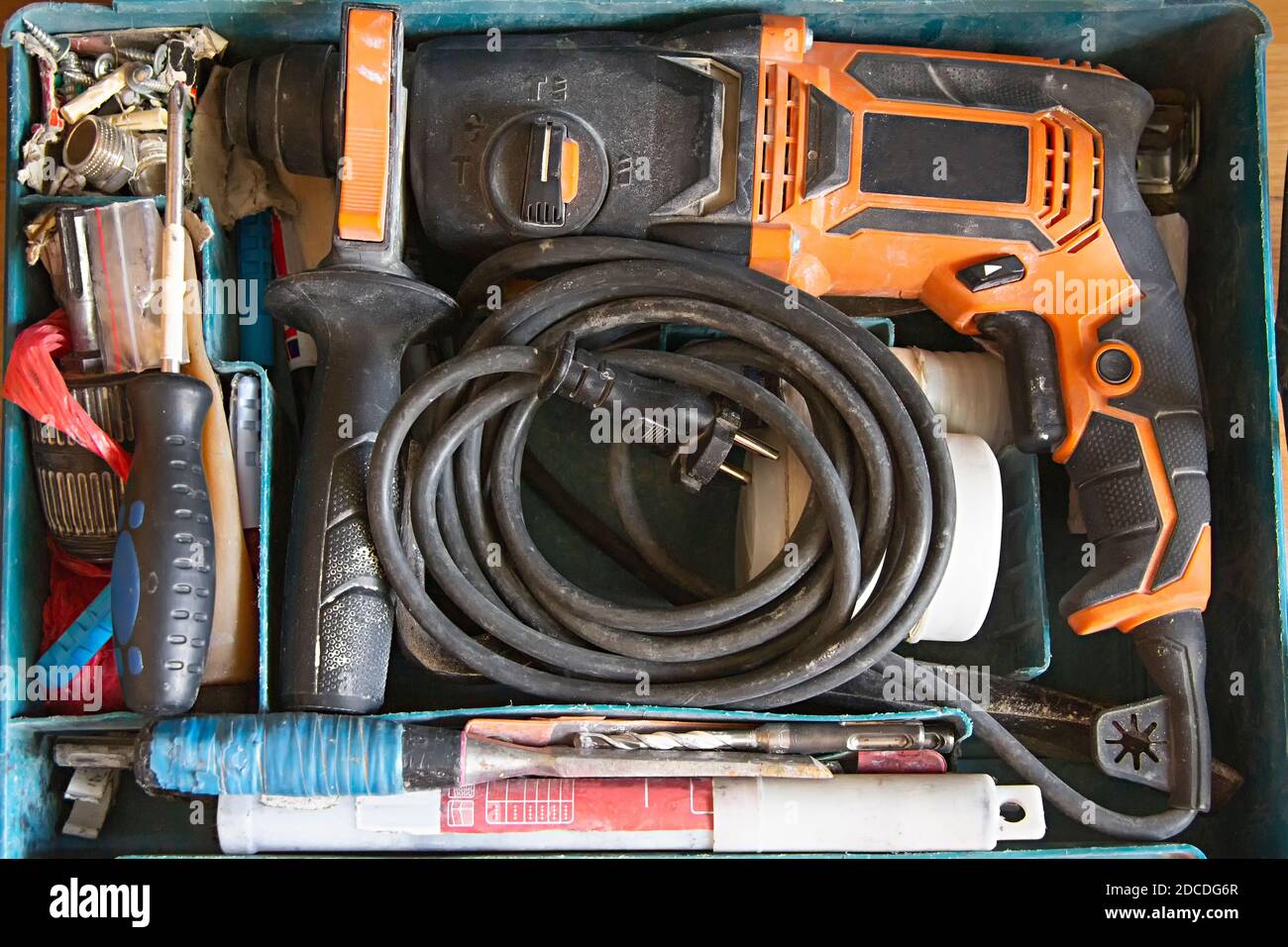 Top view of used worker's tool box, electric drill, drills, screwdriver