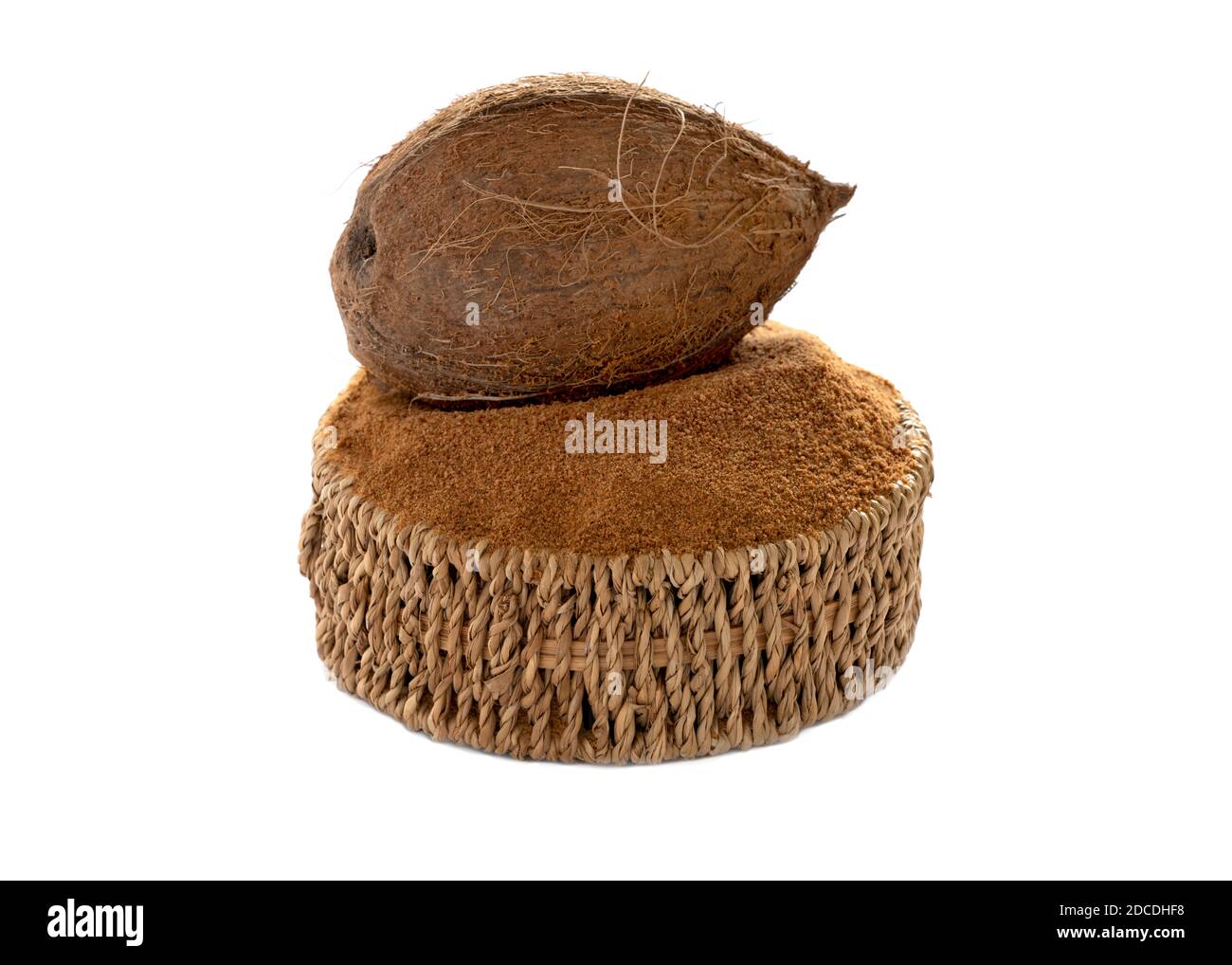 organic coconut sugar in a basket with whole coconut isolated on a white background Stock Photo