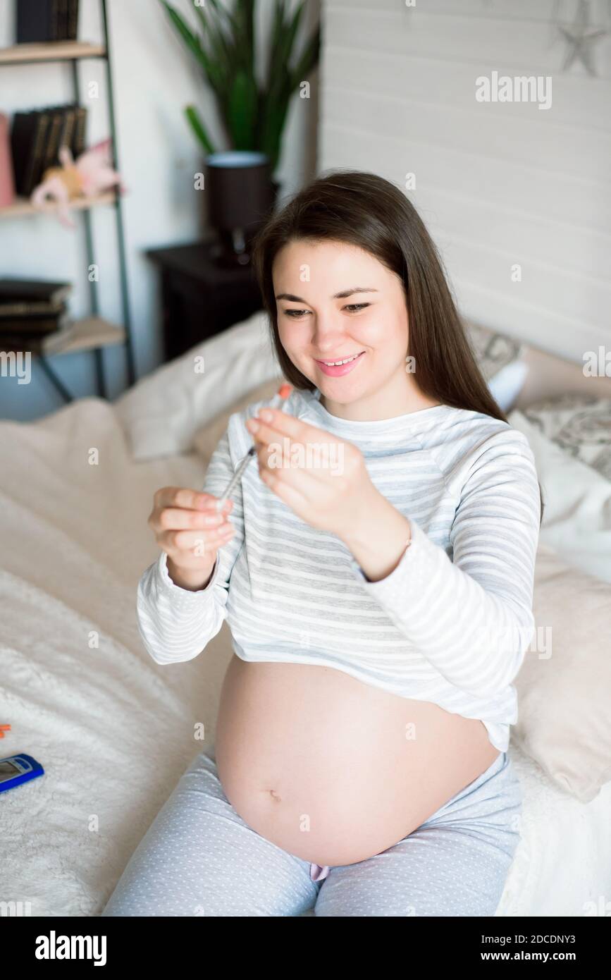 Diabetes of pregnant, insulin pen. Pregnant woman with syringe Stock