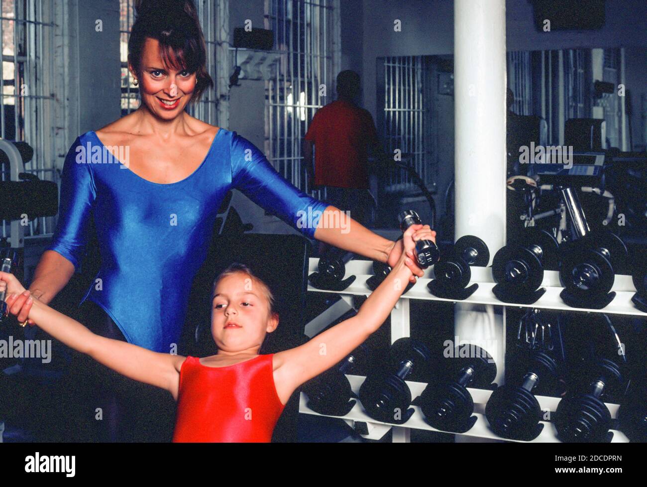 Athletic Mother Teaches her Young Daughter how to use light Weights in a Gym, 1991, USA Stock Photo