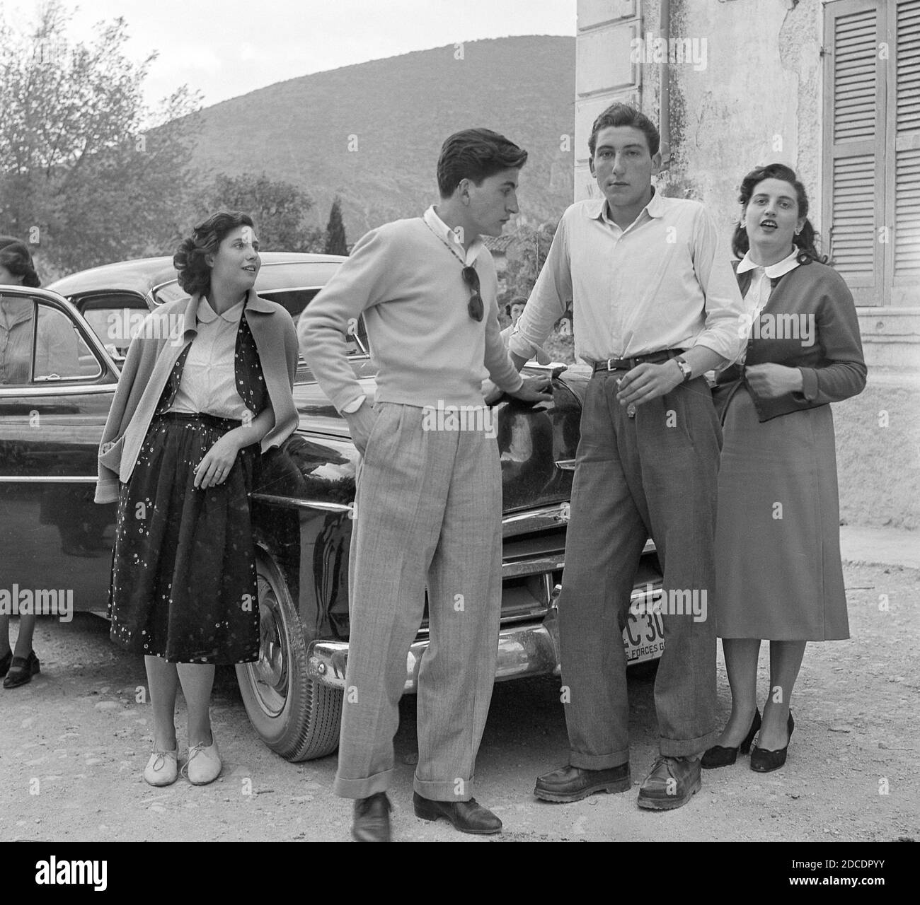 Young Adult Pose For Photos in front of an American Car, 1950s, Italy Stock Photo