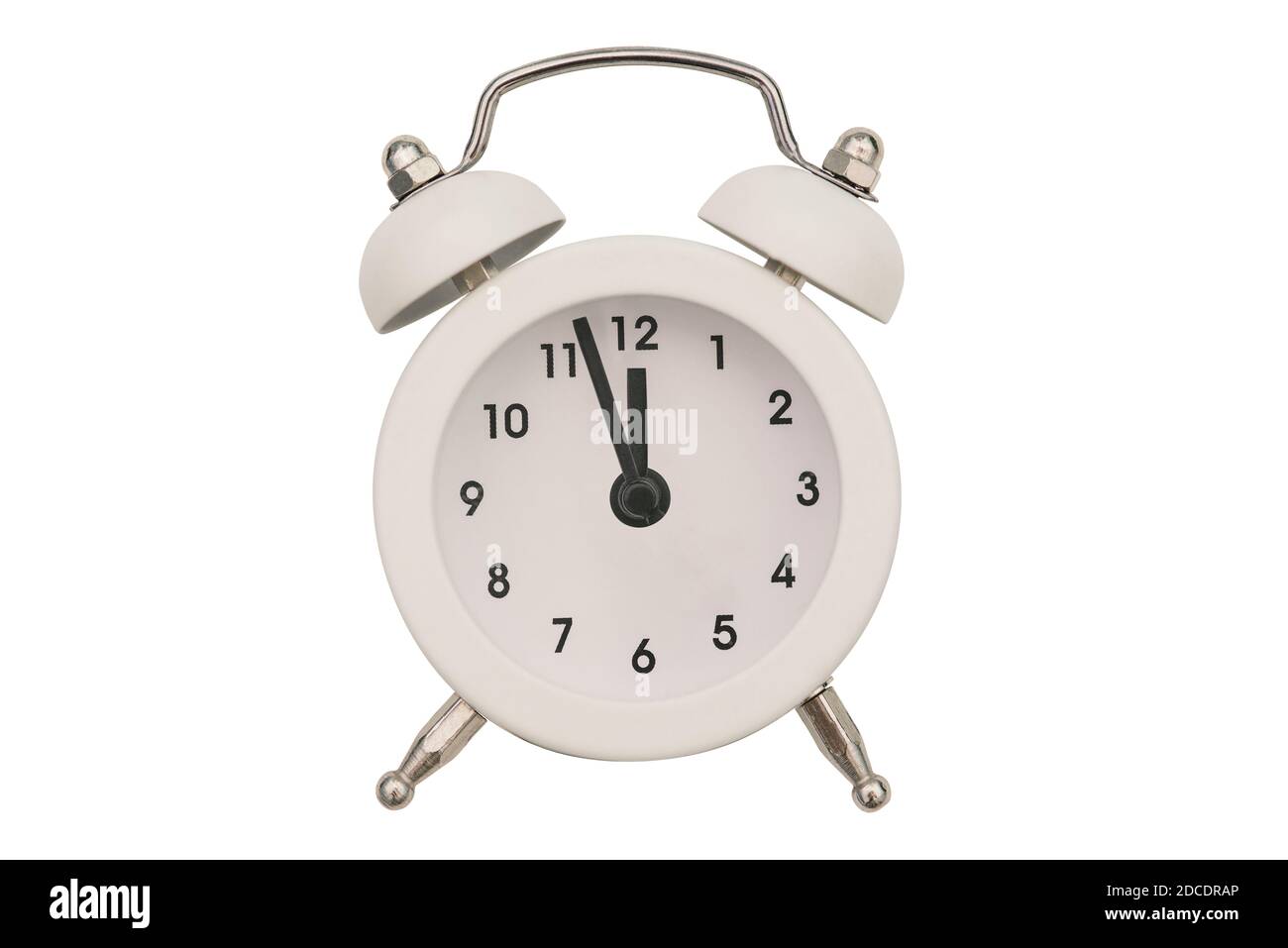 Alarm clock close-up isolated on a white background. White round clock. The hands of an old alarm clock with a bell show the time at twelve o'clock Stock Photo