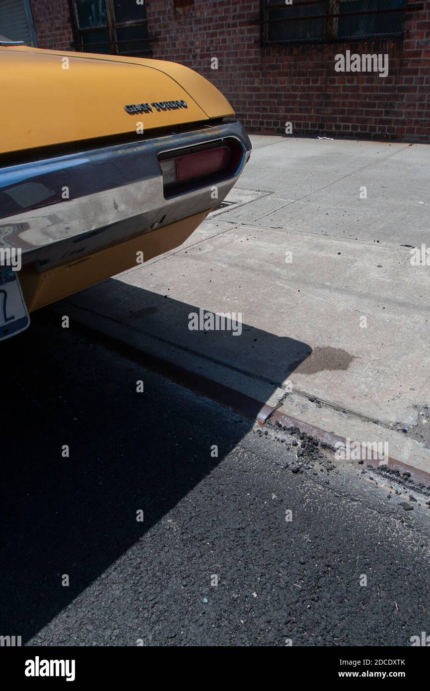 A 1980s American Classic Cadillac parked at a used car sales lot in New