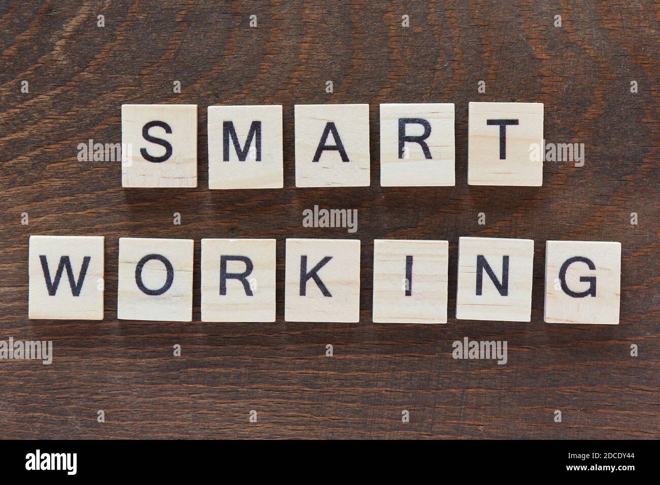 written 'SMART WORKING' with light wood letters on dark wood Stock Photo