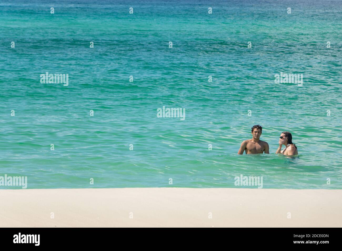 two young men in green sea  at Biloxi beach Mississippi USA Stock Photo