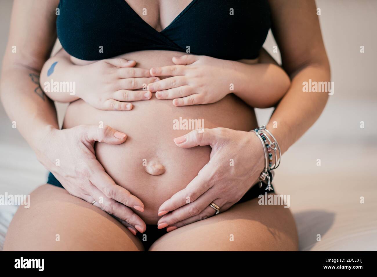 Close up picture of pregnant woman and her baby holding her belly - Baby holding the belly of his pregnant mother - Pregnant woman and her baby holdin Stock Photo
