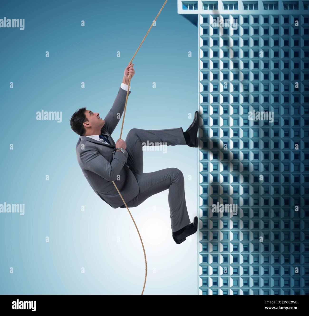 The businessman climbing skyscraper in challenge concept Stock Photo