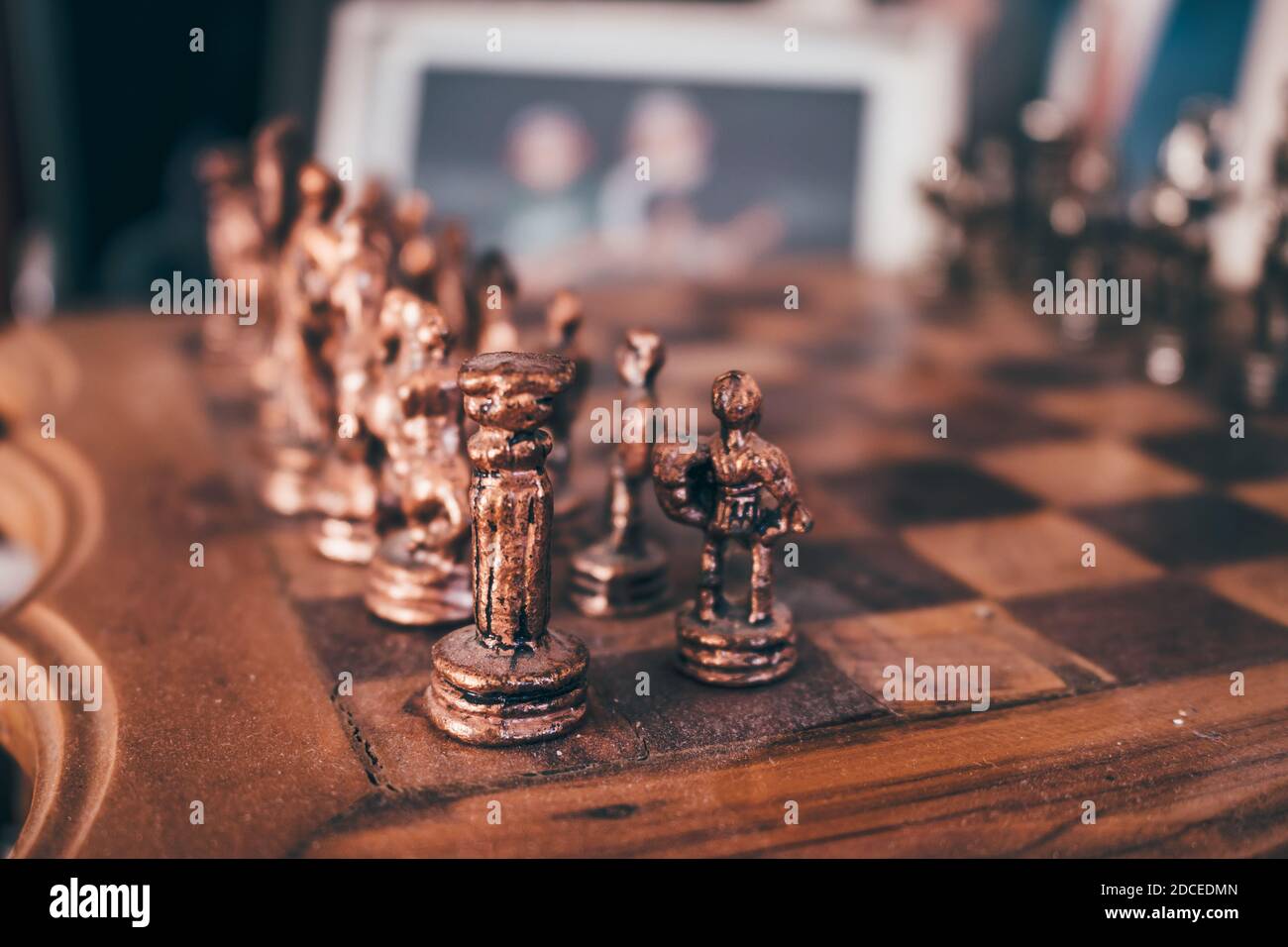 Old vintage wooden chessboard with brass pieces. Selective focus, close up. Stock Photo