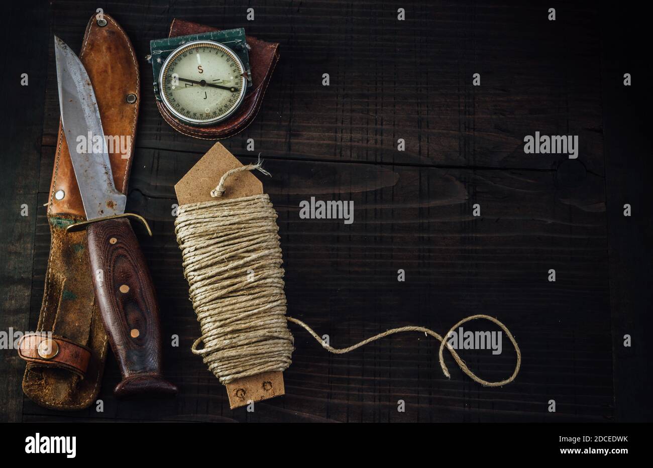 Old rusty hunting bushcraft knife, military compass and a linen rope on the  wooden table. Leather cases, copy space, top view, survival concept Stock  Photo - Alamy
