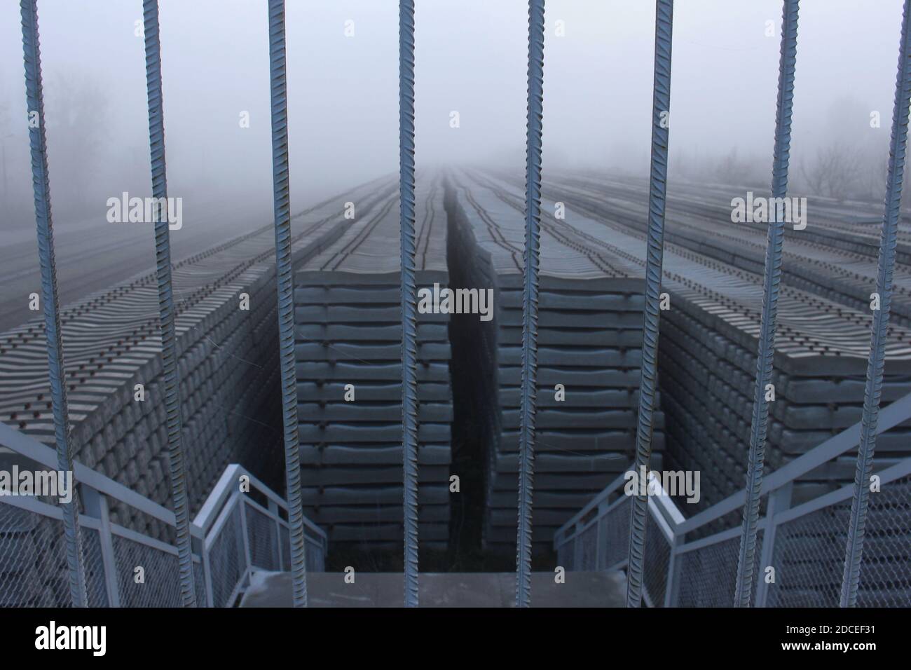 Concrete railway sleeper at a train station in Białystok during foggy weather Stock Photo