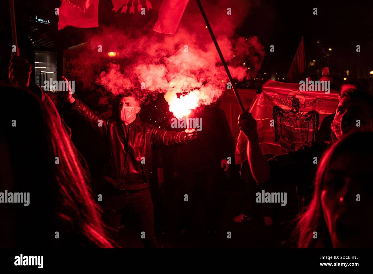 Madrid, Spain. 20th Nov, 2020. Far right wing supporter making a fascist salute holding a flare and people carrying a pre-constitutional Spanish flag during a rally to commemorate the death anniversary of Falange founder Jose Antonio Primo de Rivera. Credit: Marcos del Mazo/Alamy Live News Stock Photo