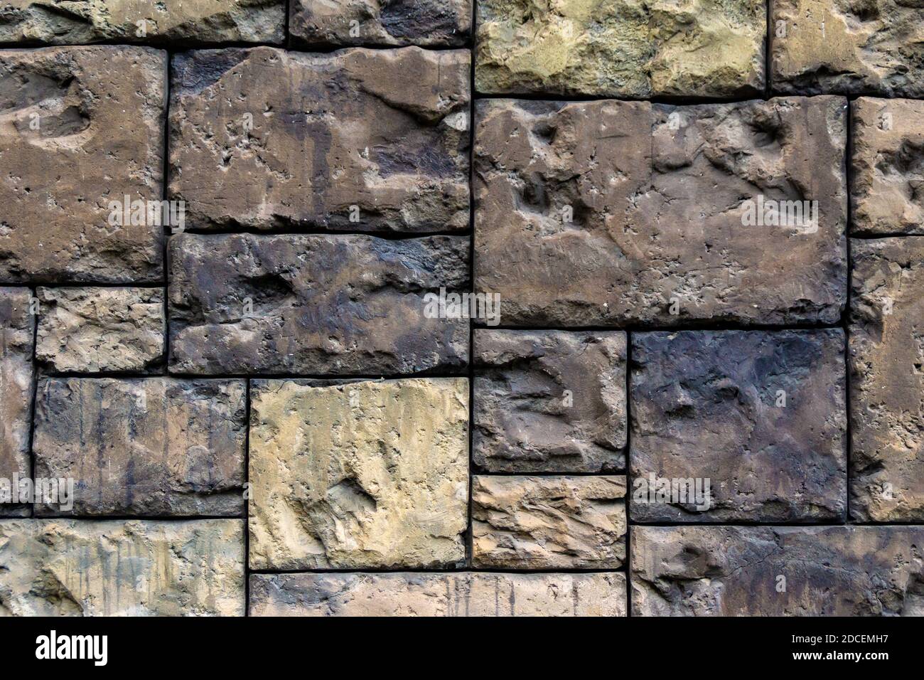 wall made of large hewn stones of various sizes, colors and structures Stock Photo