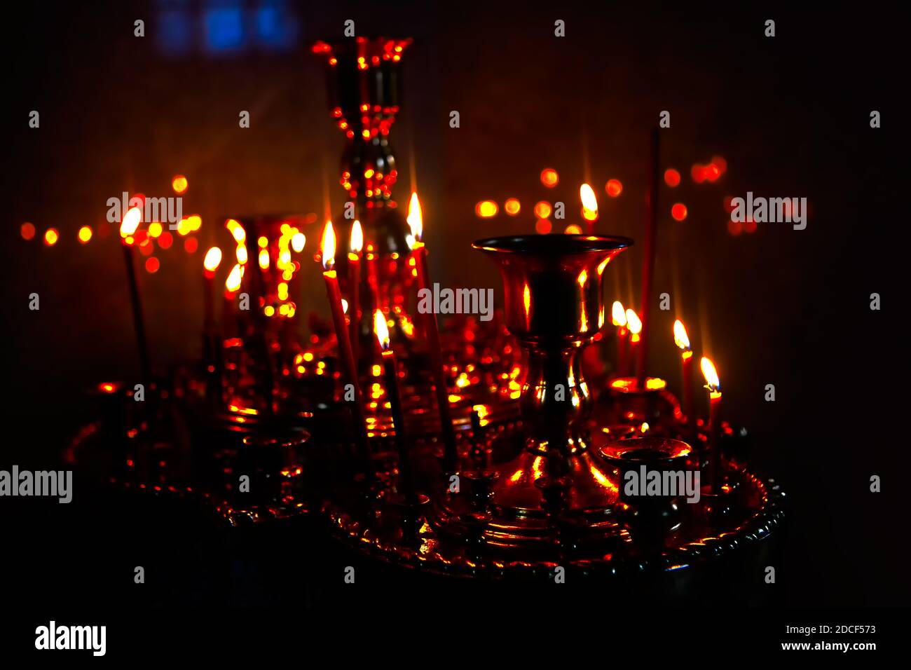 Candlestick with candles in the dim light . Praying inside the church ...