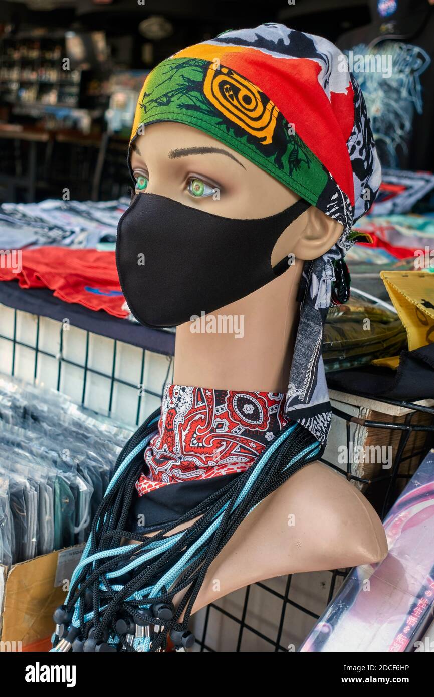 Female mannequin wearing a Covid 19 face mask and a colourful headscarf representing the new normal wear for a woman outdoors Stock Photo