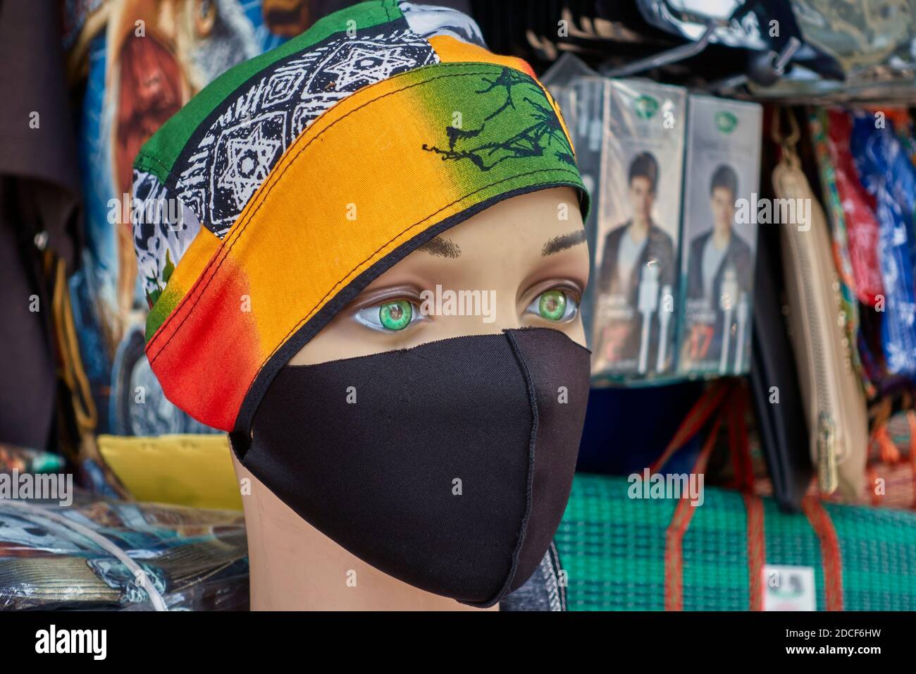 Female mannequin wearing a Covid 19 face mask and a colourful headscarf representing the new normal wear for a woman outdoors Stock Photo