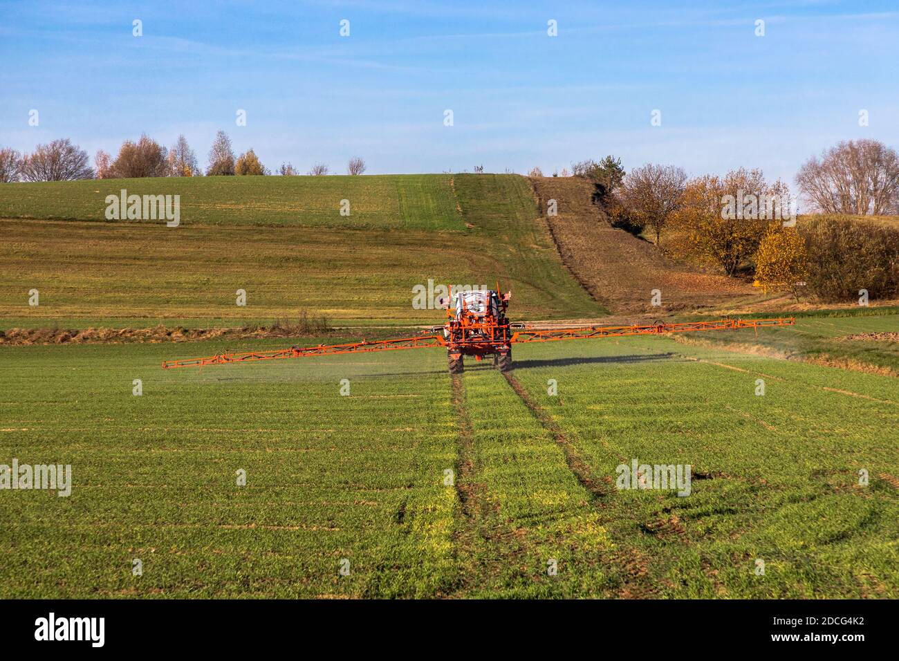 Farmer with tractor spraying herbicide Stock Photo