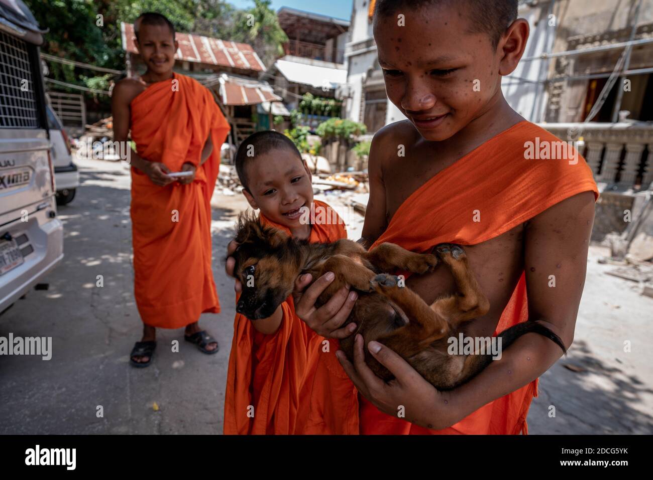 Svay Rieng, Cambodia. 18th July, 2020. Young Monks play with a dog at a pagoda.An estimated 800 people a year die of rabies in Cambodia, one of the highest deaths rates per capita in the world. At the root of Cambodia's endemic are unvaccinated dogs, in a country with one of the highest dog to human ratios in the world. Efforts at achieving herd immunity are significantly disrupted by the 3 million dogs per year slaughtered for Cambodia's dog meat trade. Some experts have warned that unless the dog meat trade is addressed, rabies will still remain prevalent. (Credit Image: © Andy Ball/SOPA Stock Photo