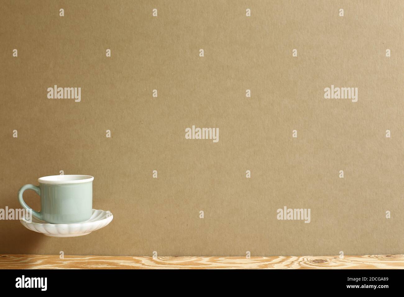 Mint green coffee cup floating on wooden table. Brown background copy space Stock Photo Alamy
