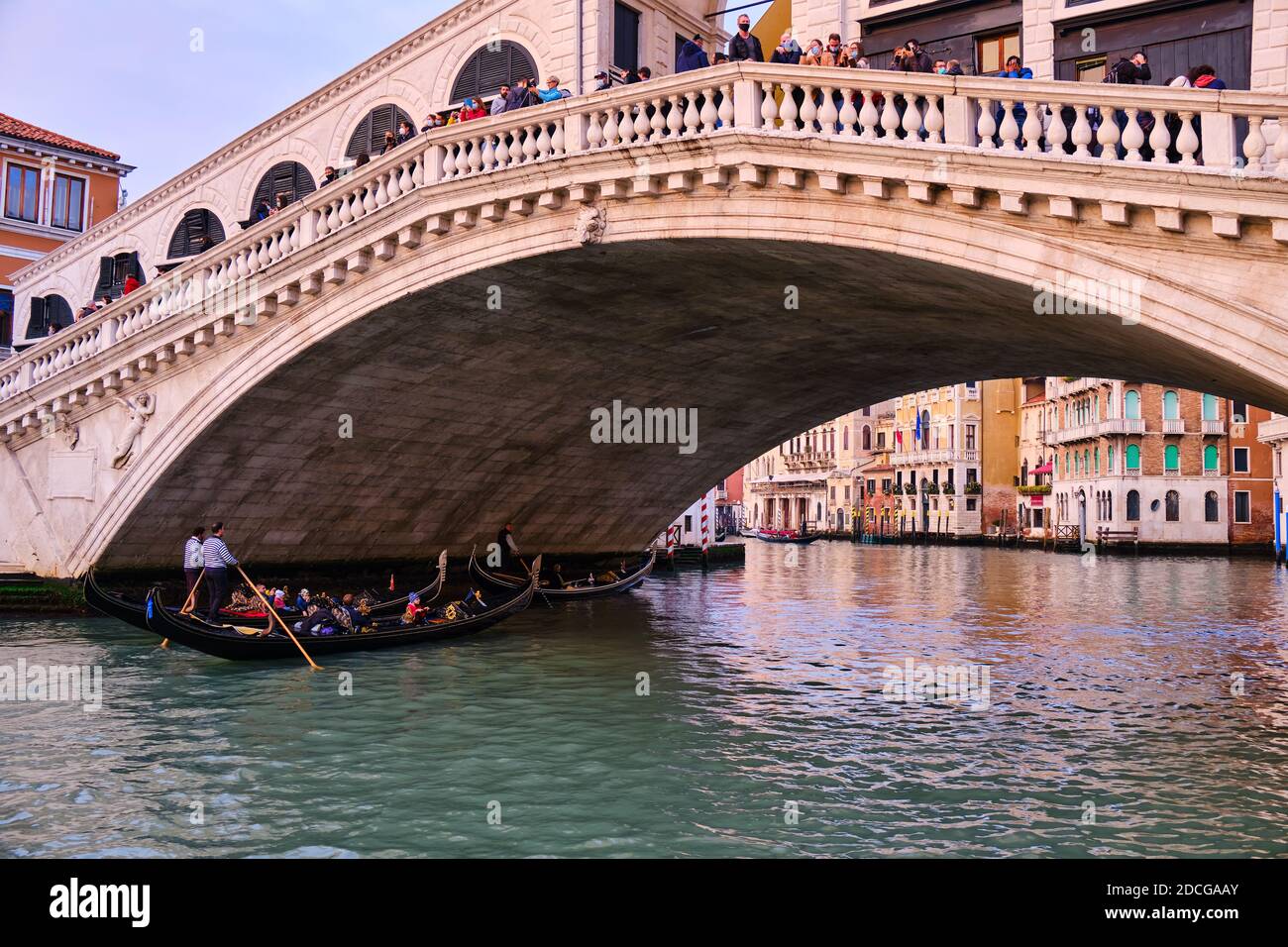 Venice, Veneto, Italy, Europe - October 16 2020: Gondola crossing the Rialto Bridge at COVID-19 time, with all the tourists wearing masks, Venice, Ita Stock Photo