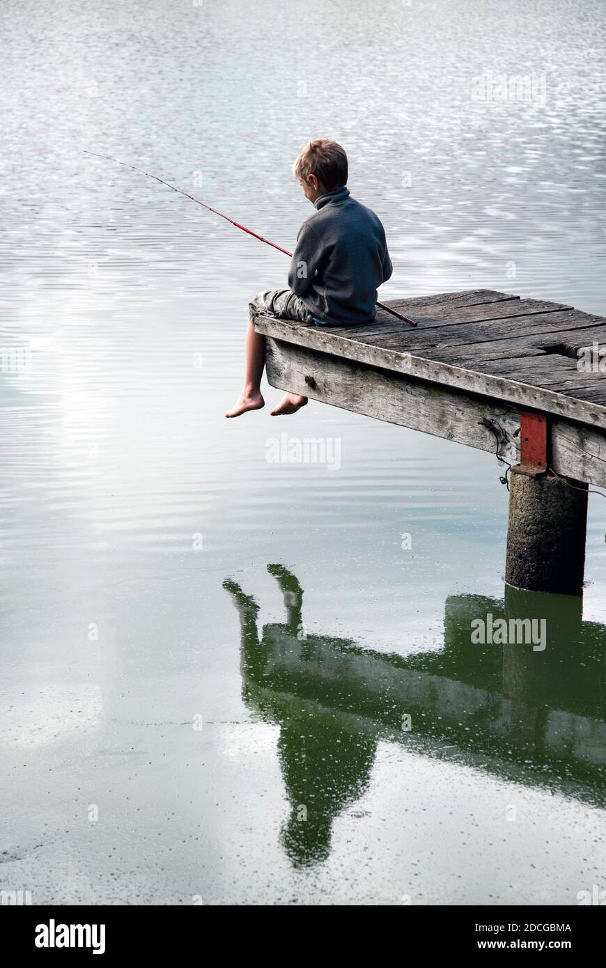 Small boy fishing in pond with cane rod and reflection while sitting on wooden jetty, France Stock Photo - Alamy Small boy fishing in pond with cane rod and reflection while sitting on wooden jetty, France Stock Photo - Alamy