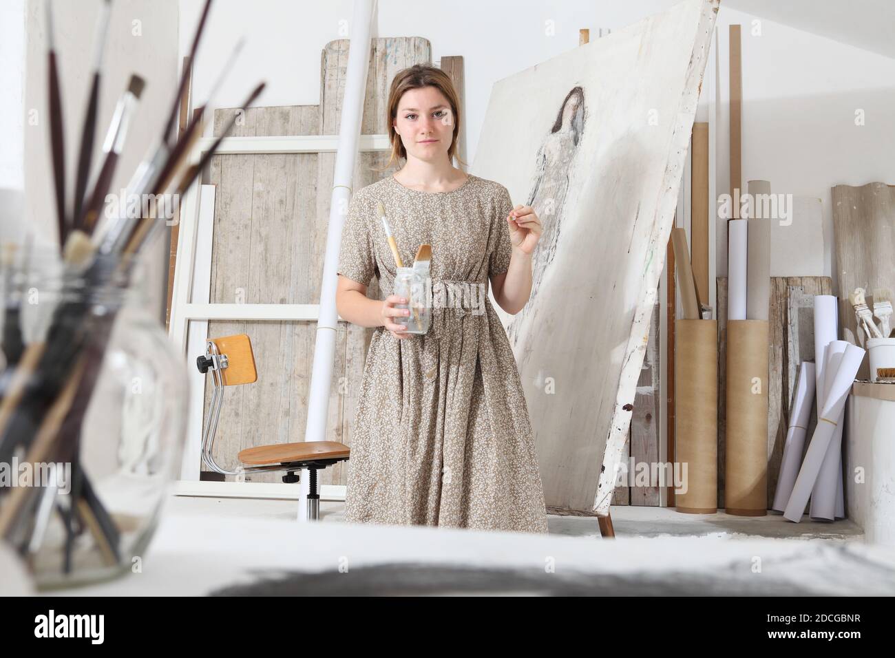 Indoor shot of young female artist looking at camera standing in front ...
