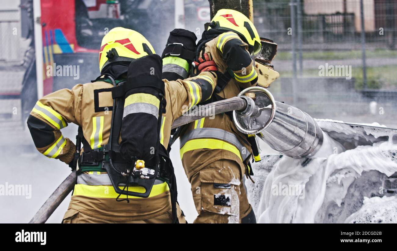 Fire drill. Firefighters extinguish fire from the nurning car using the