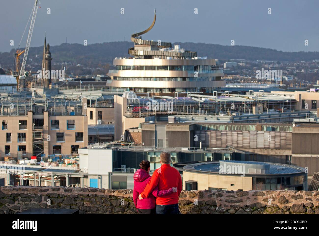 Princes Street and Calton Hill, Edinburgh, Scotland, UK. 21 November 2020. Sunshine and showers with blustery winds for those on Calton Hill. Pictured: This couple look towards the top half of the new St James Quarter building viewed from Calton Hill is set to open up in Easter 2021 and is now visible from various angles on the Edinburgh skyline. Credit: Arch White/Alamy Live News. Stock Photo