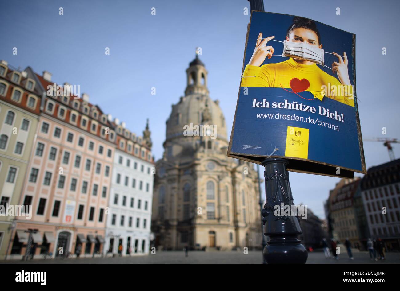 Dresden, Germany. 21st Nov, 2020. The official poster of the state capital Dresden, which points out the use of mouth and nose covers, hangs on a lantern on the Neumarkt in front of the Frauenkirche. The federal and state governments have decided on a partial lockdown. Among other things, restaurants, leisure facilities and cultural institutions will have to close. This still includes the distance requirement and the obligation to wear masks. Credit: Robert Michael/dpa-Zentralbild/dpa/Alamy Live News Stock Photo