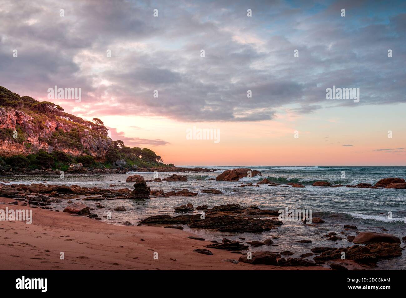 A coastal scene at sunset on a rocky shore Stock Photo