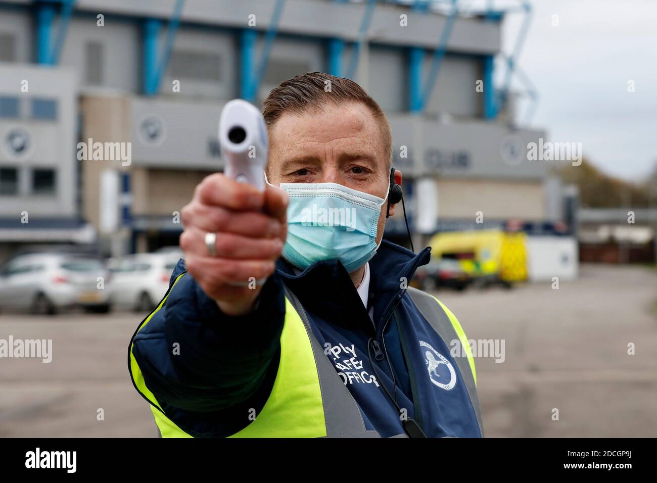 The Den, Bermondsey, London, UK. 21st Nov, 2020. English Championship Football, Millwall Football Club versus Cardiff City; Safety Steward scanning temperatures of permitted visitors outside The Den Stadium before kick off Credit: Action Plus Sports/Alamy Live News Stock Photo