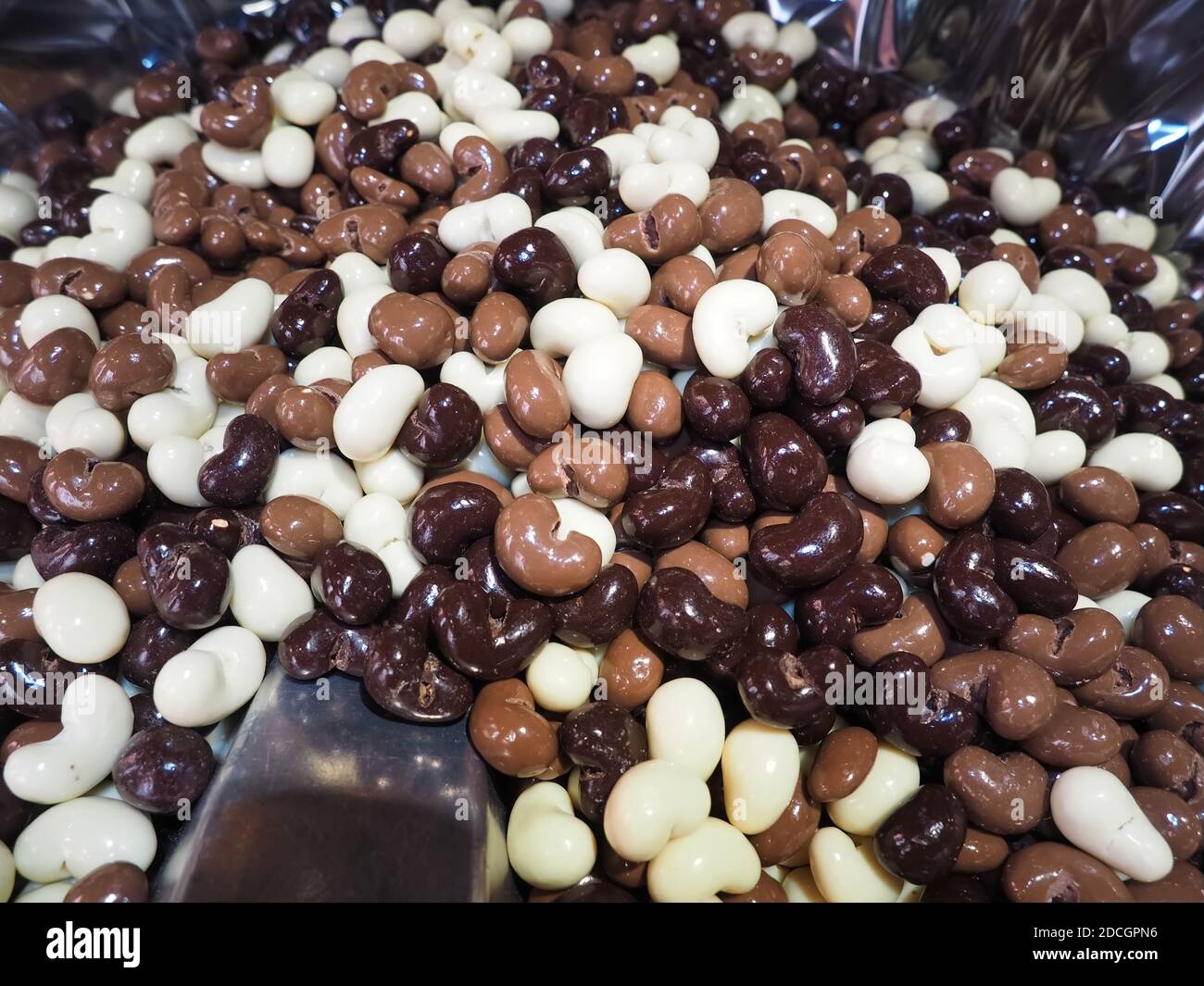 Pile of chocolate coated nuts with brown, dark and white chocolates