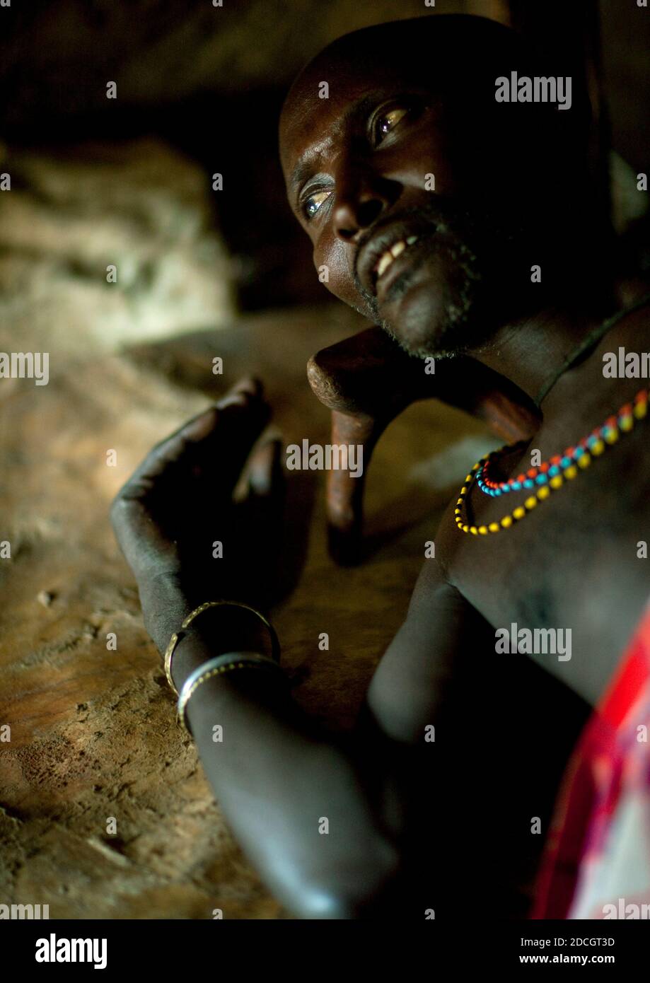 Portrait of a Samburu tribe warrior resting on his bed, Samburu County, Maralal, Kenya Stock Photo