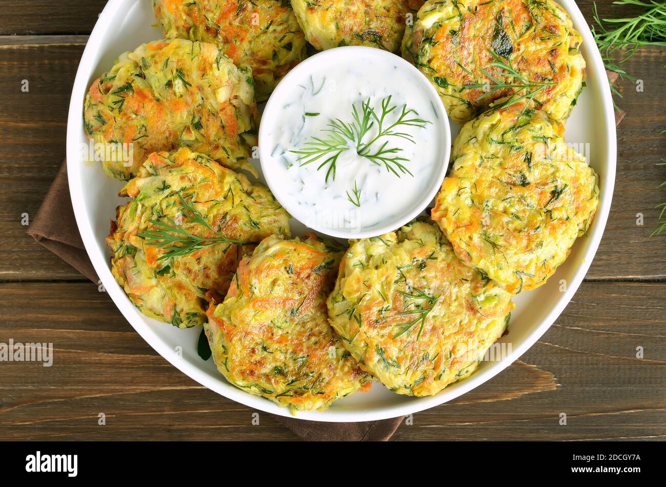 Diet vegetable cutlet from zucchini, carrot, herbs on wooden table.  Top view, flat lay Stock Photo