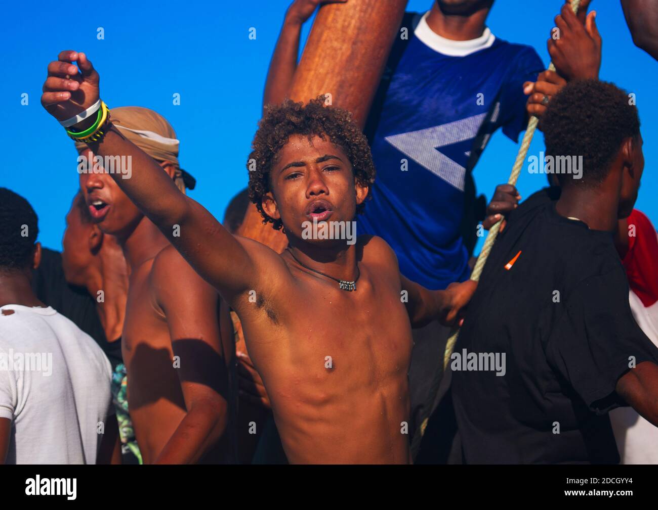 Young boy raising punch on boat, Lamu County, Lamu, Kenya Stock Photo