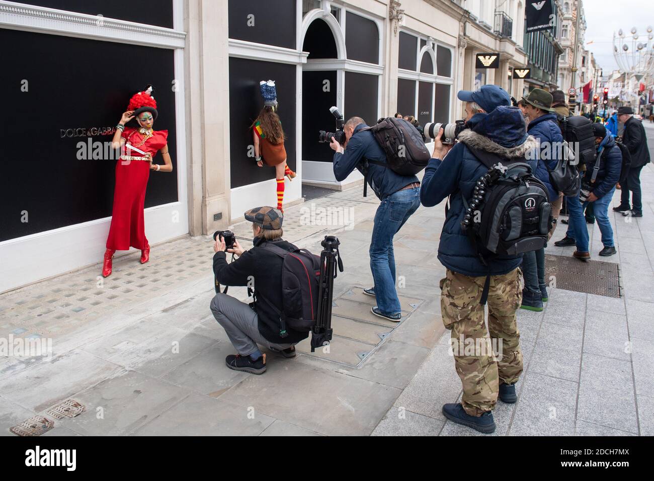 Models pose for photographers as they showcase clothes by fashion designer Pierre Garroudi, during a flashmob fashion shoot on New Bond Street, London. Stock Photo
