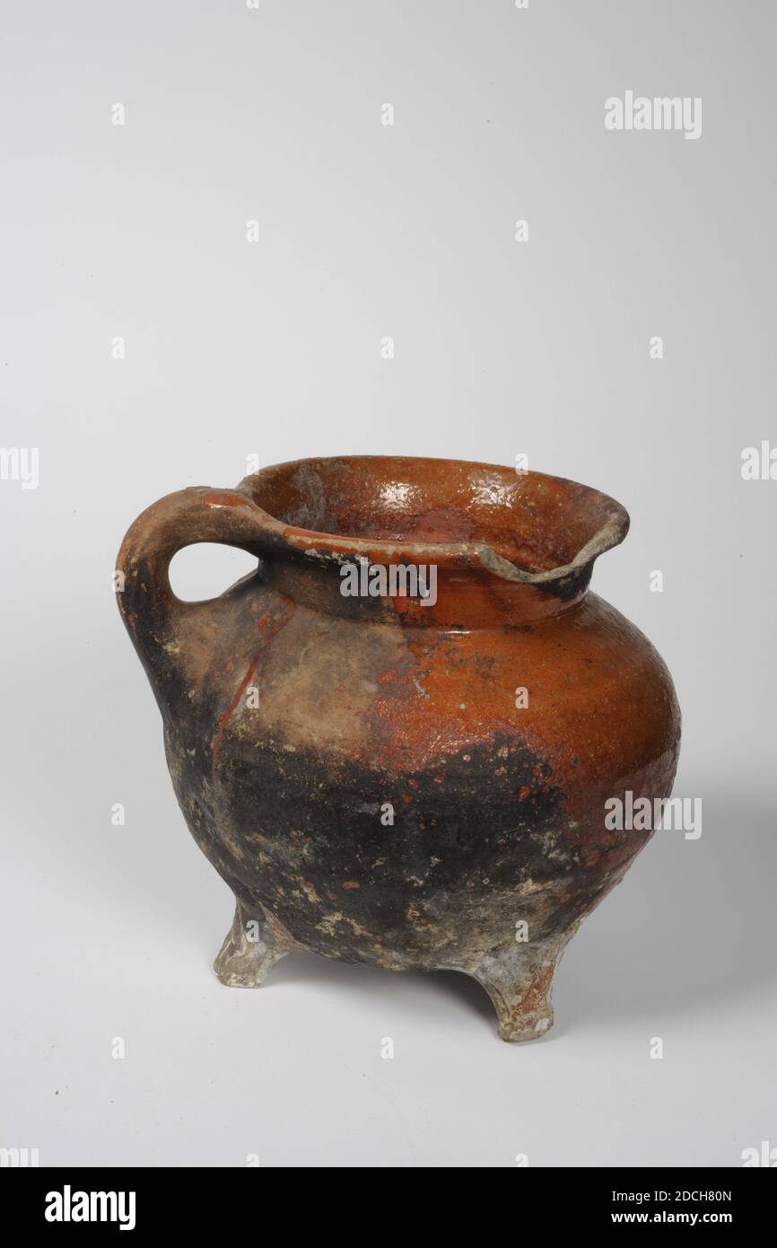 Pot on three legs, with ear, red earthenware with local brown glaze.  Lightly damaged. Fourteenth century. Piece missing from the belly wall,  with old glueing., Grape, pottery, turntable (black), h: 12.8 cm