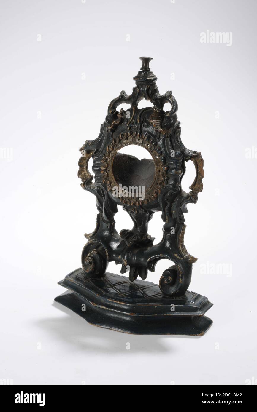 watch stand, Anonymous, 18th century, General: 28 x 17.5 x 7cm 280 x 175 x 70mm, Watch stand of green painted spruce with carving of Louis XV style curls. The stand has a round, openwork dial opening. Decorated all around with a wavy edge and with holes. On both sides an openwork half arch with seed beads. On top of a copper button. The whole is placed on a console that is notched in diamond shape. The bottom is hollowed out. The back is roughly cut away and has a semicircular opening with a slot for the timepiece. Without a clockwork, 1892 Stock Photo