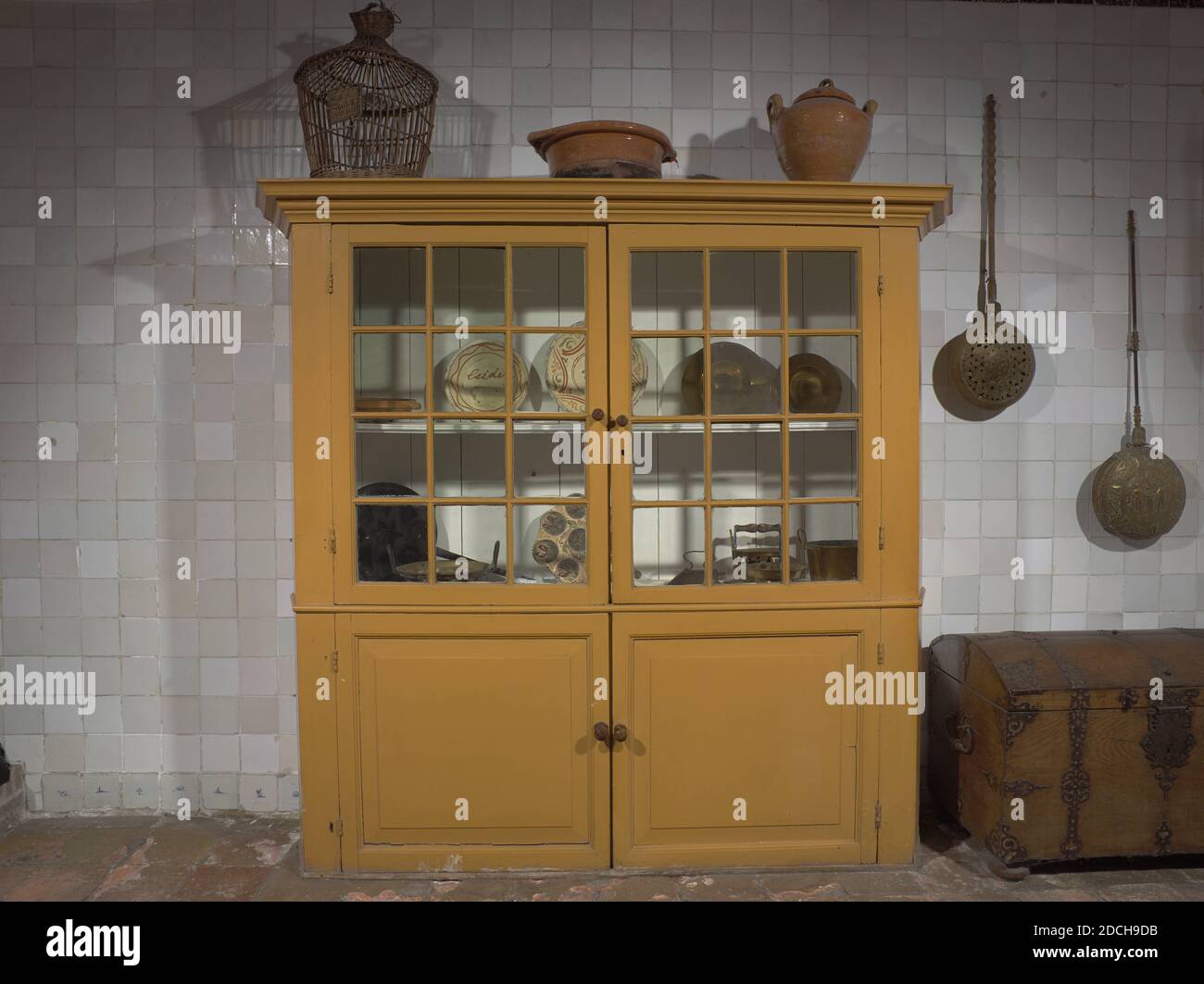 cupboard, Anonymous, 17th century, glass, wood, painted, General: 202 × 218 × 43cm 2020 × 2180 × 430mm, Kitchen cabinet with two glass doors. The cabinet is painted yellow and has cross-corner posts wider than the side wall. The two upper doors have 25 glass panes and turned knobs. The bottom doors have deep bossing. The outstanding cornice has ojief profiles. The cabinets are separated by a central rail across the entire width, 1936 Stock Photo