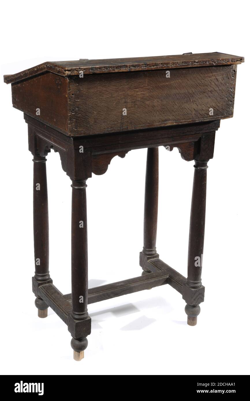 lectern, Anonymous, 17th century, metal, oak, Oak lectern on a base with a protruding sloping flap and a new ledge. The lid of the lectern is hinged to the top frame. The desk contains two side-by-side oval bent metal lock plates with protrusions. The base stands on Doric columnar and twisted articulation and houses with a double T-shaped connection in between. The base is on ball legs. Along the top edge of the chassis run sawn-out S-shaped volutes and consoles at the bottom. The key is missing, General: 124 x 78 x 63cm 1240 x 780 x 630mm Stock Photo