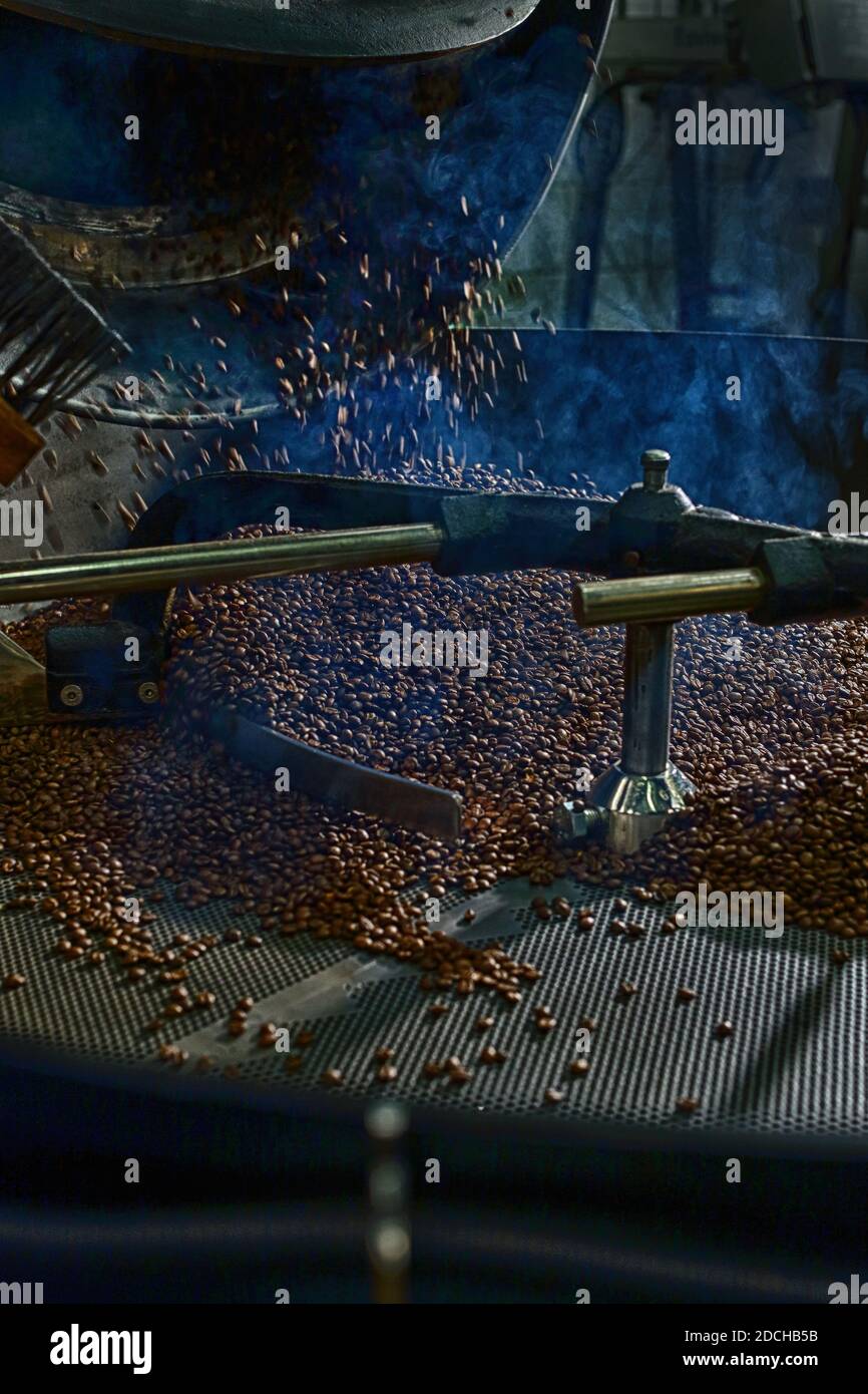 opening a coffee roaster, beans falling out into the cooling pan