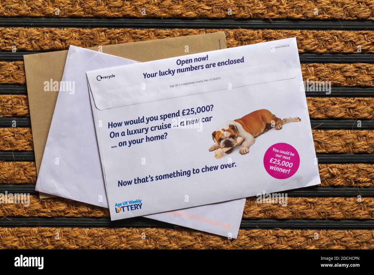 Post mail on doormat - Age UK weekly lottery Stock Photo