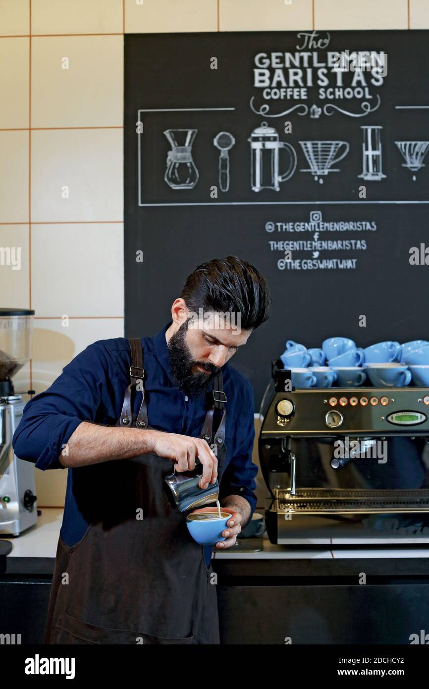 Great Britain / England / London /Coffee Style /Barista pouring flat white, a variation on the classic cappuccino in front the espresso machine. Stock Photo